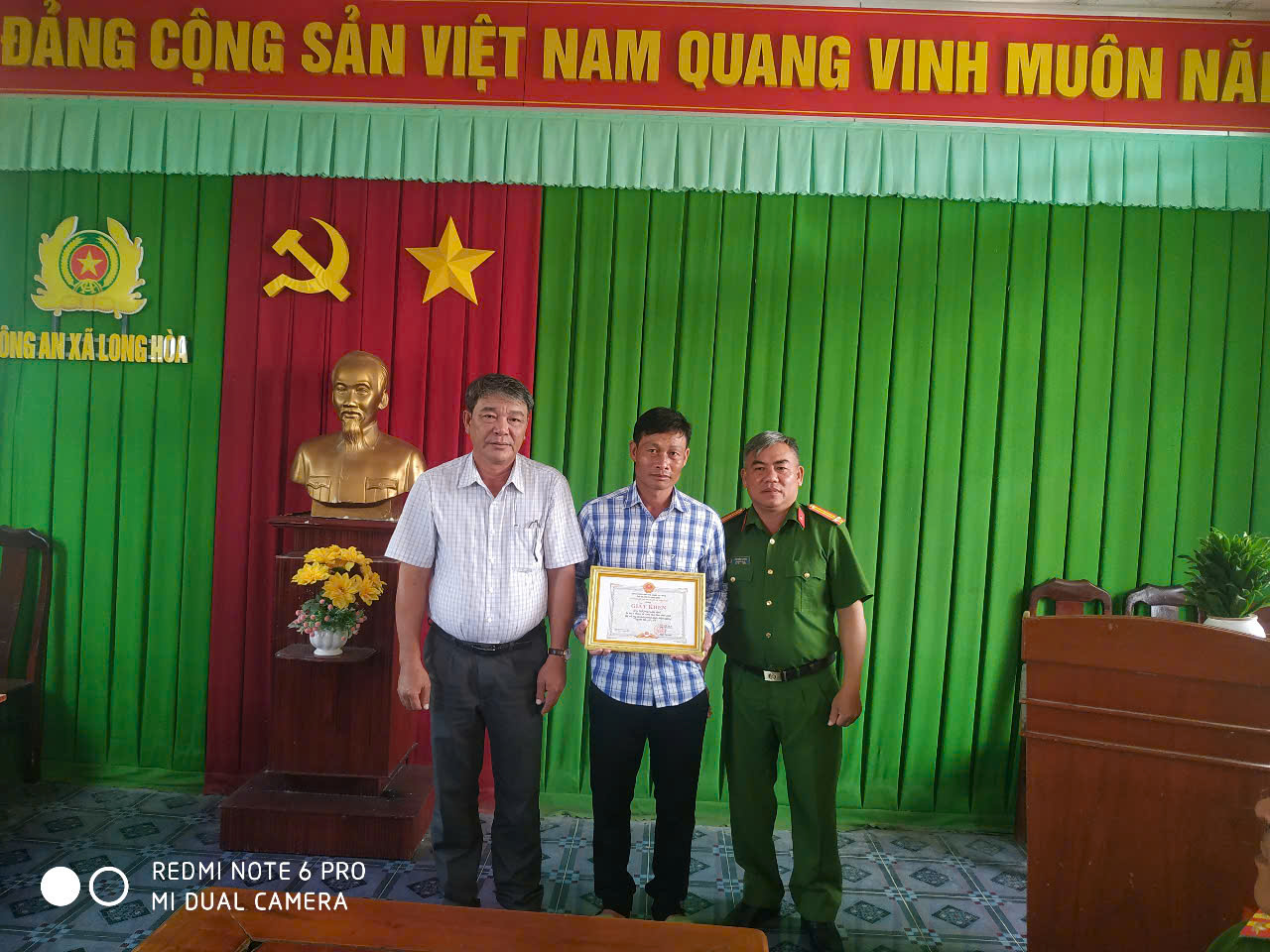 Chủ tịch Ủy ban nhân dân xã Long Hòa trao quyết định khen thưởng cho người dân nhặt được của rơi trả lại cho người đánh rơi